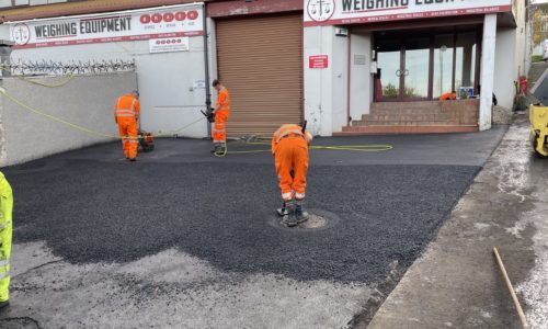 Armstrong's Roads & Driveways crew levelling tarmac for a car park repair in Scotland